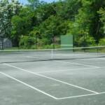 Har Tru court with fencing and hitting backboard